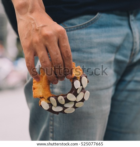 Man Hold Donut on Street