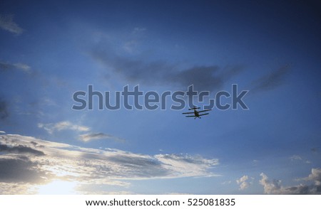 Retro airplane on the sunset sky