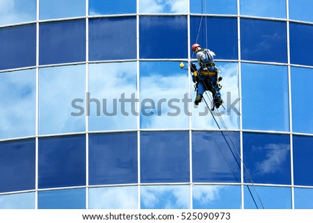 Male worker in overalls professional repair the windows in high-rise Royalty-Free Stock Photo #525090973