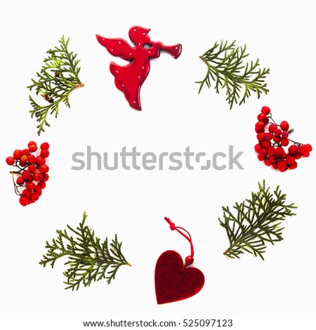 Christmas frame made of green thuja twigs, rowan berries and xmas tree decorations on white background. Top view, flat lay. Square
