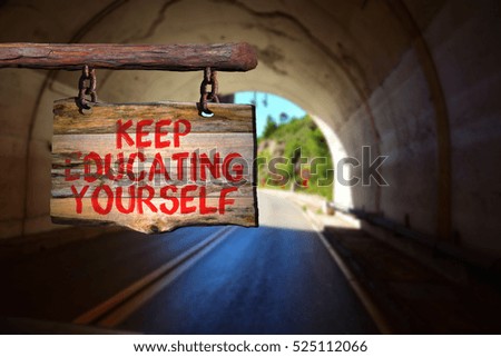 Keep educating yourself motivational phrase sign on old wood with blurred background