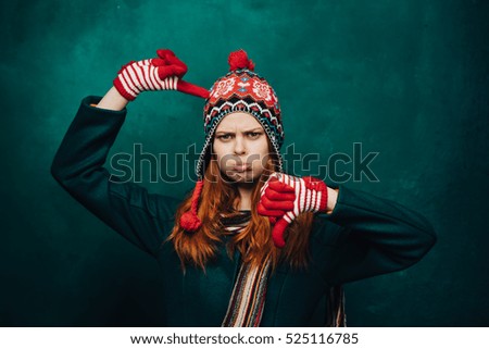 
Young woman in winter clothes Christmas dissatisfied hamming for the camera
