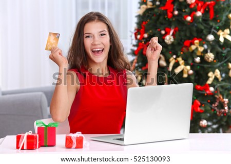 Young woman shopping online with credit card at home for Christmas