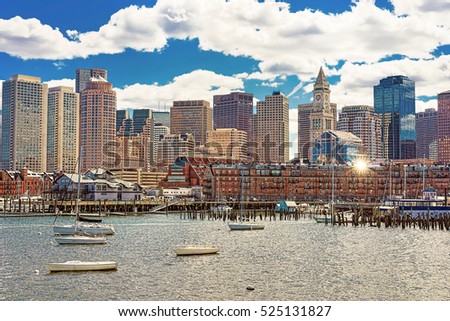 Harbor with different sailboats and the skyline of Boston in the United States. The city is located near various water facilities and floating transport is very popular there.