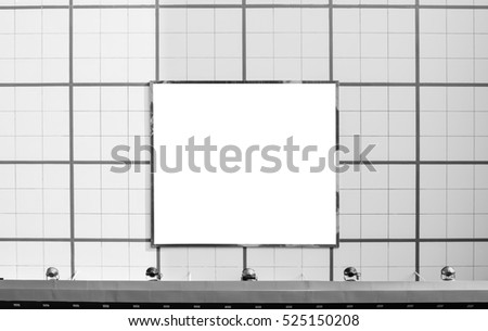Blank advertising metallic frame billboard with spotlight on modern office building wall or  department store building in the city, black and white, front view, mock up useful for advertisement