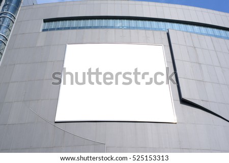 Blank advertising billboard in metallic frame on modern office building or outside department store building in the city, low angle view, useful for advertisement