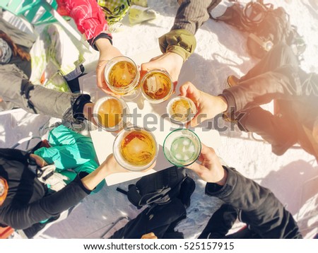 winter holidays - group of friends drinking beer on break at ski resort