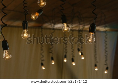 Black lamps hang from the wooden ceiling