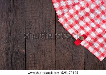 Rustic wooden boards with a red checkered tablecloth. Top view.