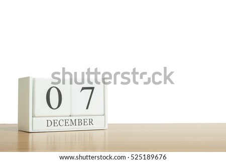 Closeup surface white wooden calendar with black 7 december word on blurred brown wood desk isolated on white background with copy space , selective focus at the calendar