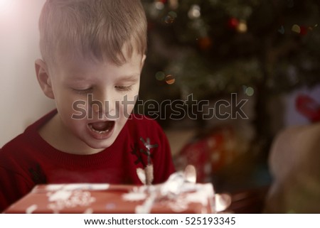 Young boy opening his presents on Christmas