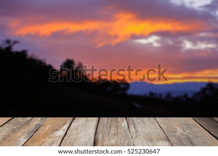 Wood table top on blurred Image of silhouette of forest trees at beautiful sunset..can be used for display or montage your products