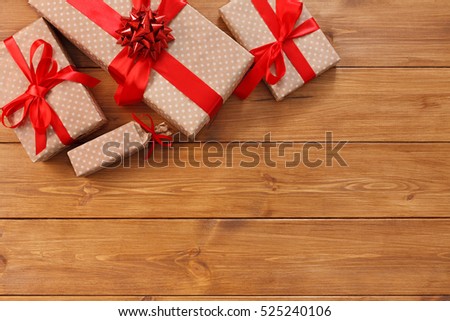 Presents for any holiday concept. Gift boxes frame, top view with copy space on wood table surface background. Border of packages with red satin ribbons for christmas, valentine day or birthday