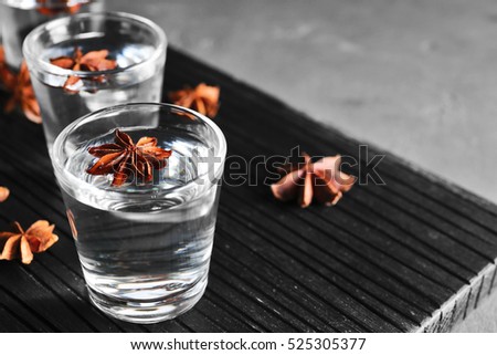 Vodka with anise on wooden board closeup