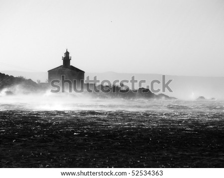  Picture represents the lighthouse while blowing strong wind.Picture is made in black white.