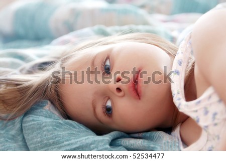 Beautiful little girl in the morning lying in bed Royalty-Free Stock Photo #52534477