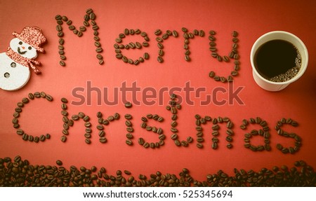 "Merry Christmas" coffee beans and christmas decorations on red paper texture