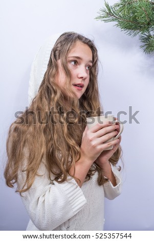 the girl in a white jacket and a white cap drink hot cocoa in a white cup on a white background. neutral  color.