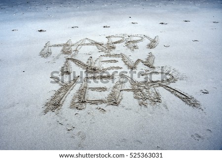 Happy new year written on sand at sunset. Happy New Year lettering on the beach. "Happy New Year" drawn on sand on a beach, closeup shot. Happy New Year  written in sand, on tropical beach.