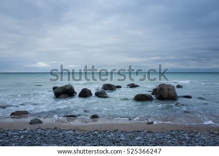 Mons Klint Denmark. Beautiful nature and landscape photo. Cloudy sky, stones, rocks, ocean and water. Nice outdoors image of coastline. Beach, waves and sand. Lovely, calm, joyful and happy picture,