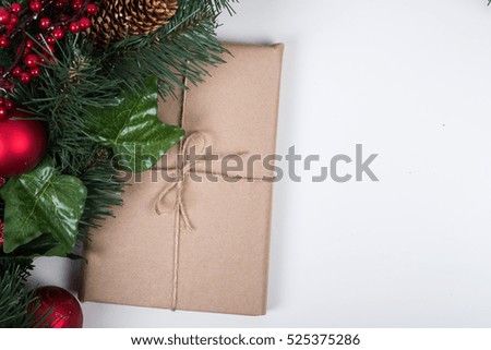 Kraft gift box with christmas balls and tag on a white background