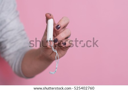 Woman's hand holding a clean cotton tampon