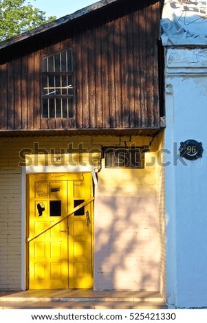 yellow boarded up door in an old house in the sun