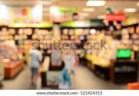 Blurred image of a man reading books in a bookstore.