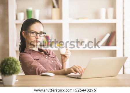 Portrait of beautiful businesswoman using laptop at workplace. Project concept
