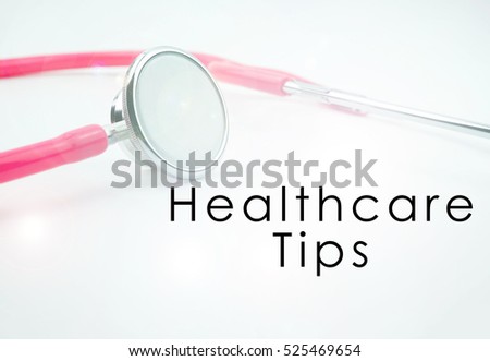 Conceptual image with word HEALTHCARE TIPS with the view of pink stethoscope on the white background. Medical conceptual. copy space