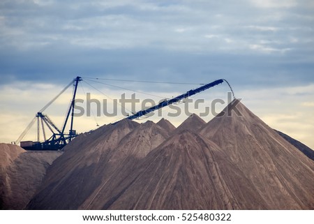 Extracting and mining potassium and magnesium salts.Large excavator machine and Huge mountains of waste ore in the extraction of potassium. Belarus, Soligorsk. Royalty-Free Stock Photo #525480322