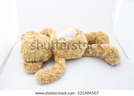 Teddy bear alone in white room,Sad,Damaged,abandon Royalty-Free Stock Photo #525484507