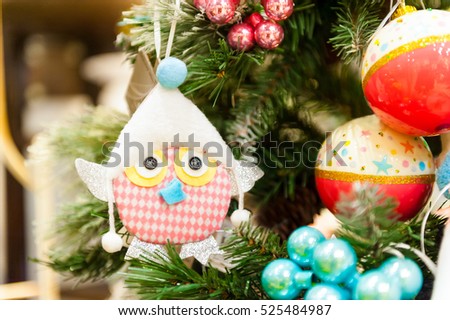christmas Toy hanging on branch Burning Candles, Boxes, Balls, Pine Cones, Walnuts, Branchesin the background other decorations and garlands. copy space.
