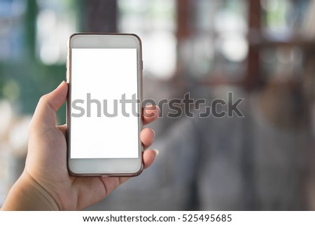 using smart phone in cafe. hand holding smart phone white screen vintage tone. hand holding using mobile phone.
