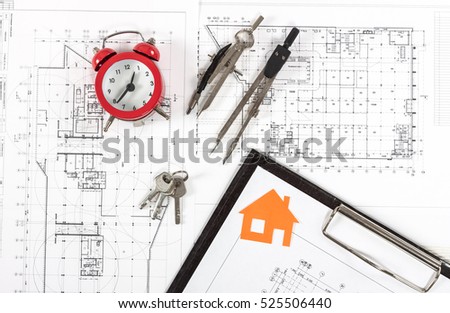 Architect workplace top view. Architectural project, blueprints, red alarm clock, keys, divider compass and pencil on desk table. Real Estate Concept.