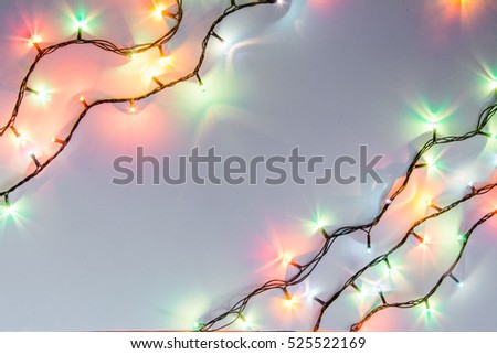 Christmas romantic lights frame on white background with copy space. Decorative garland in clean space. Clear perfect beautiful decoration for intimate evening dinner. Studio close up photo. Seamless.