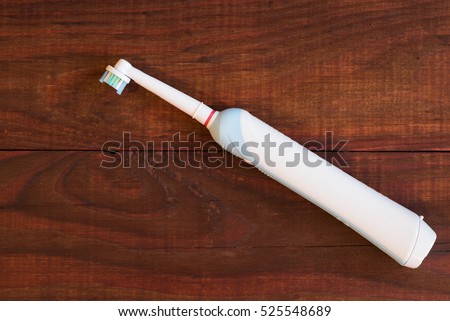 Electric toothbrush on a wooden background.
