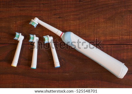 Electric toothbrush on a wooden background.