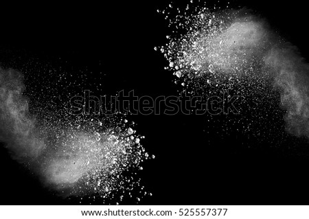 Freeze motion of white dust explosion on black background. Stopping the movement of white powder on dark background. Explosive powder white on black background. Royalty-Free Stock Photo #525557377