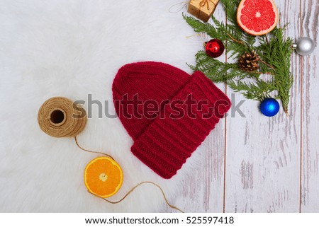 New Year's Concept. Burgundy winter hat, an orange Christmas tree decorations. White background