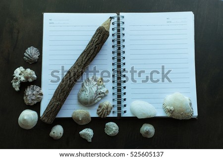 The notebook and a lot of shell on the table.