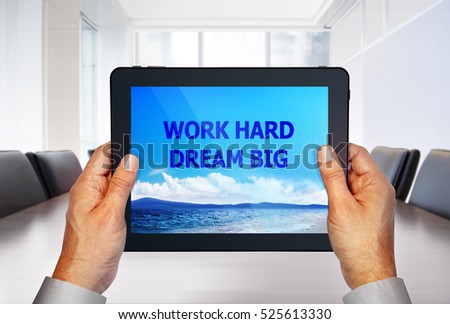 touch pad with image of motto on screen in hands