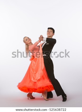 Two young ballroom dancers in studio taken against a high-key white background