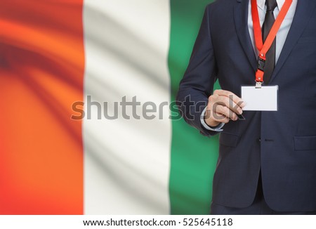 Businessman holding name card badge on a lanyard with a flag on background - Ivory Coast