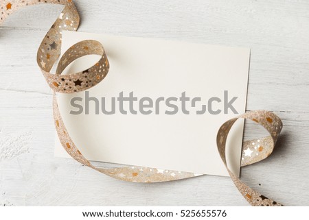 white greeting card and red ribbon on old wooden background