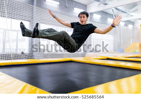 A young man trampolining in fly park Royalty-Free Stock Photo #525685564