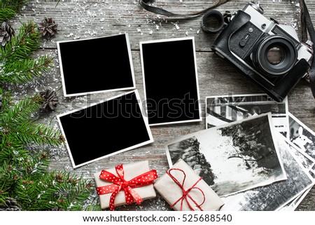 Vintage photo camera on christmas wooden background with blank photo frame, notebook and gift boxes. top view. flat lay