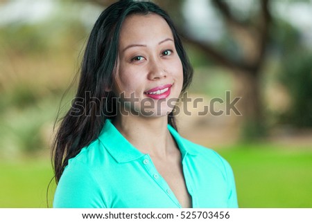 Young Asian Woman Relaxed Smiling In Portrait Wearing Green Polo Shirt Outside.