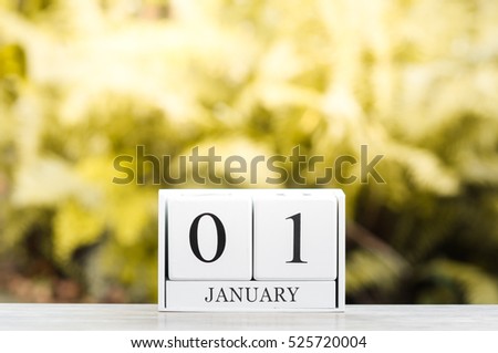 January 1st.Happy new year.Cube calendar on wooden table with Bokeh background.