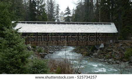 Covered bridge over running mountain river